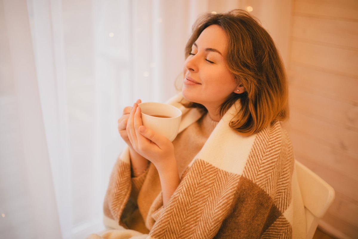 A woman relaxing at home with a warm drink
