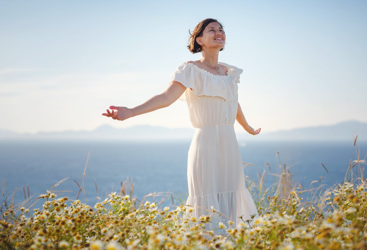 A woman breathing in fresh air in a field of flowers